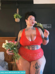 Woman in a red outfit holding flowers indoors