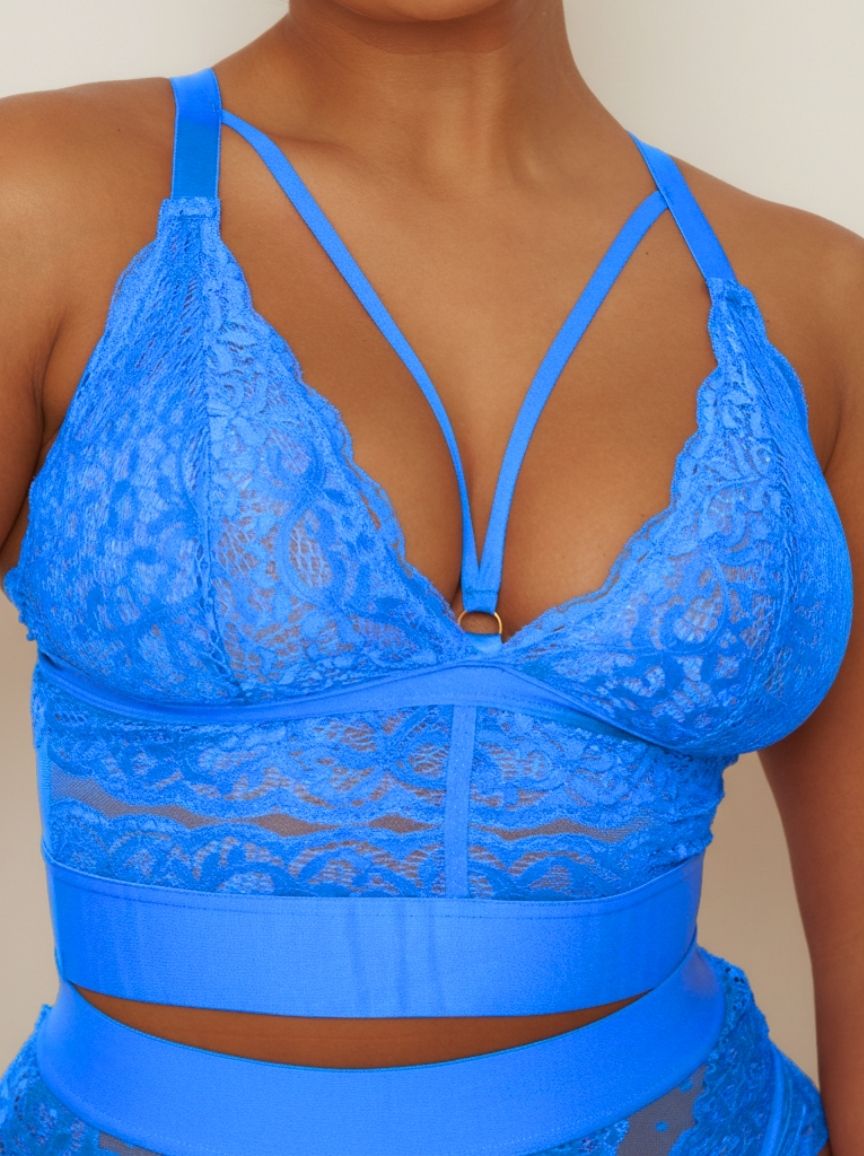 Blue lace bralette worn by a person against a neutral background