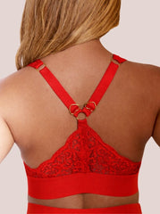 Red lace bralette worn by a person on a plain background
