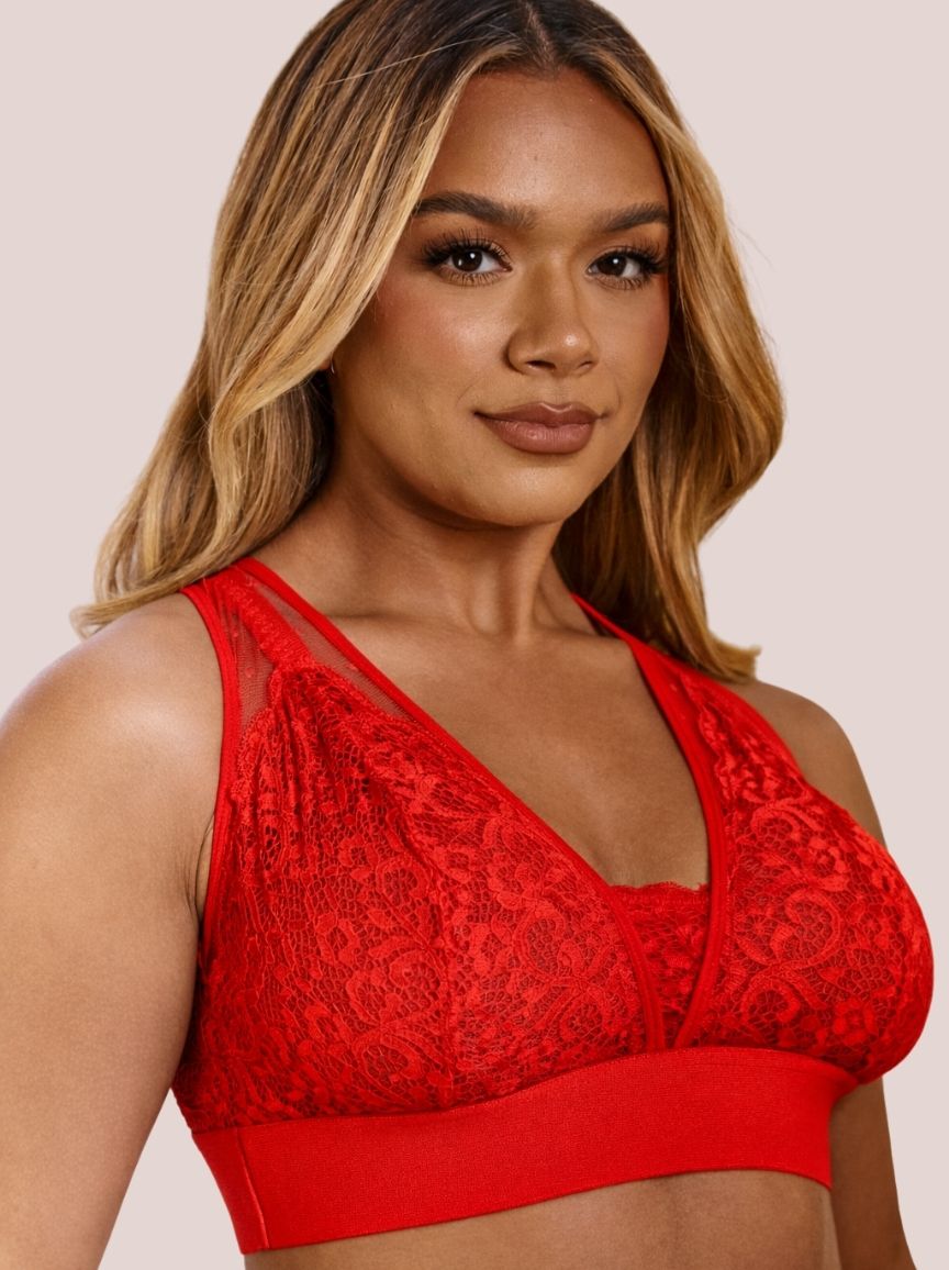 Woman wearing a red lace bralette against a beige background