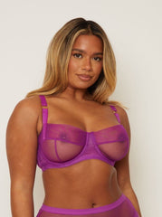 Woman wearing a purple bra and panties set against a plain background