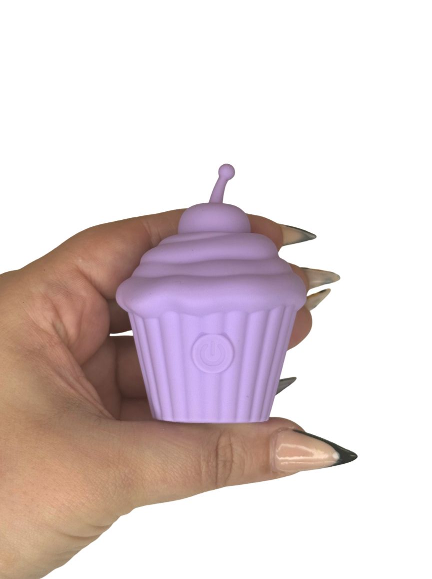 Lilac coloured cupcake shaped discrete sex toy in hand for size context